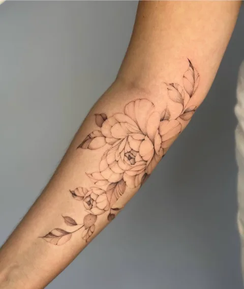Florales Tattoo mit feinen Linien und Schattierungen am Arm. Arbeit von Max