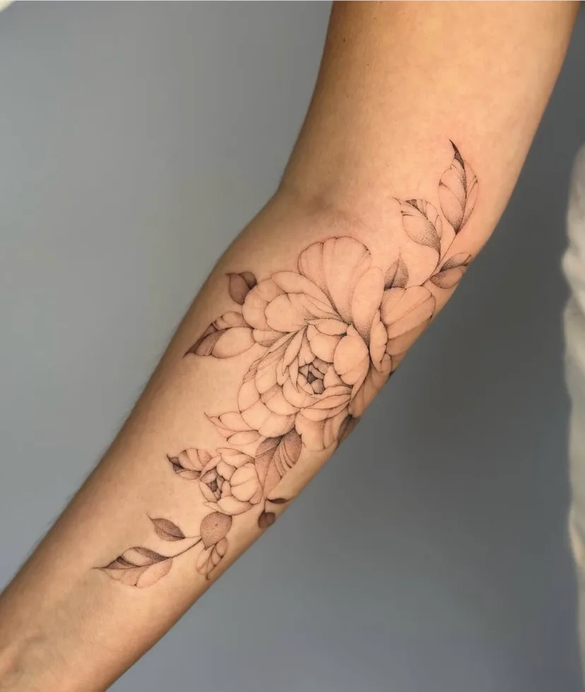 Florales Tattoo mit feinen Linien und Schattierungen am Arm. Arbeit von Max
