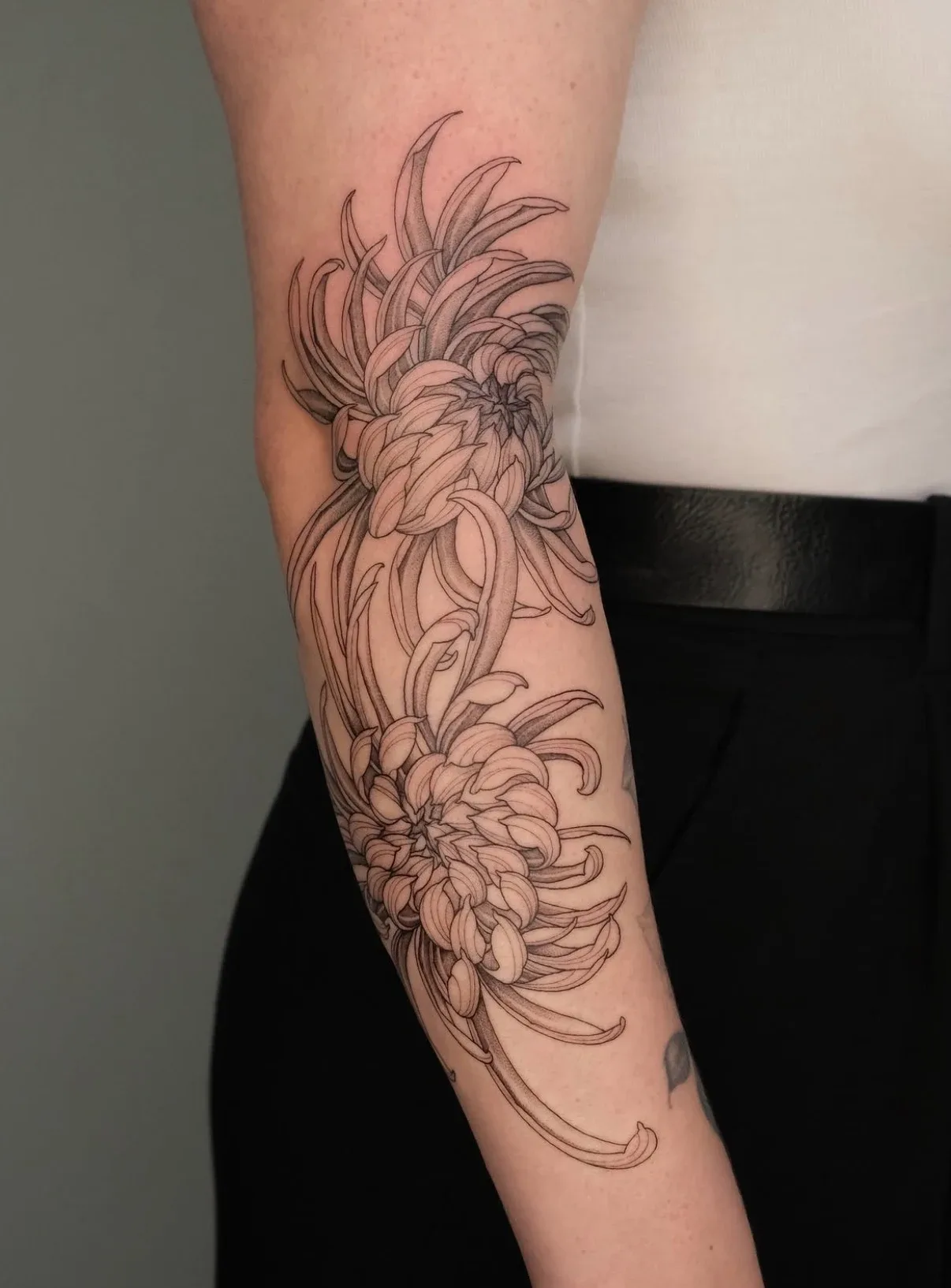 Großes florales Linientattoo am Arm. Arbeit von Max